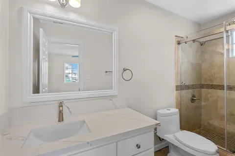 a bathroom with a sink a toilet and shower