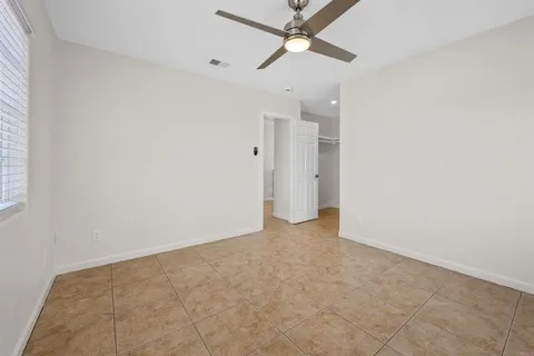an empty room with fan and entryway
