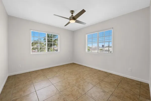 a view of an empty room with a ceiling fan and a window