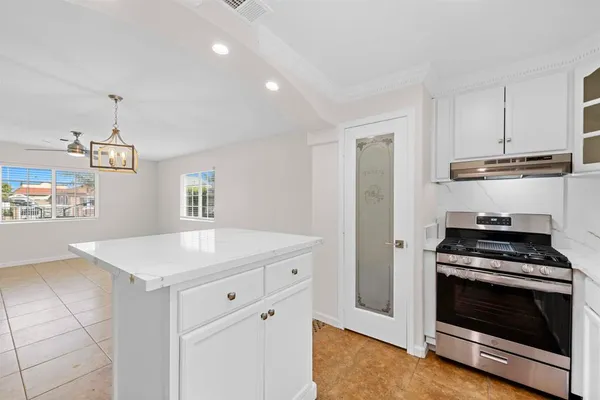 a kitchen with a stove and white cabinets
