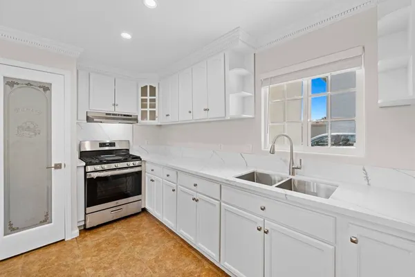 a kitchen with white cabinets sink and stainless steel appliances