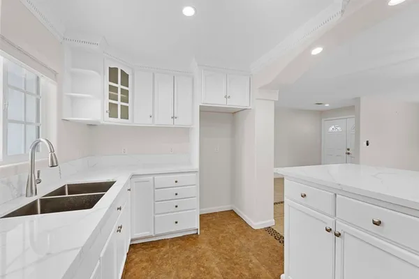 a kitchen with white cabinets and sink