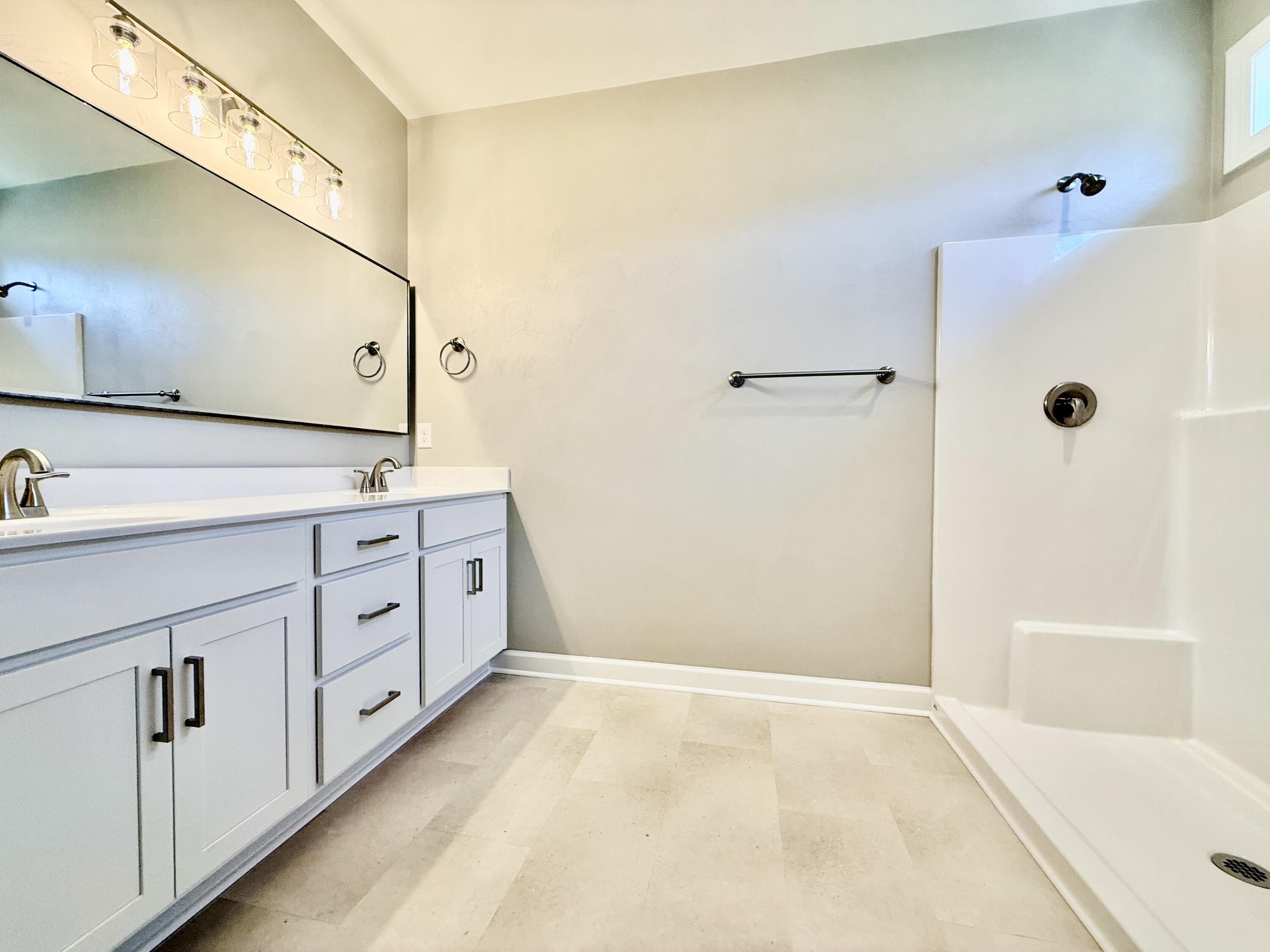 5185 Cove Road Roanoke, VA 24019 - Photo 12 of 18 a bathroom with a double vanity sink a mirror and a bathtub