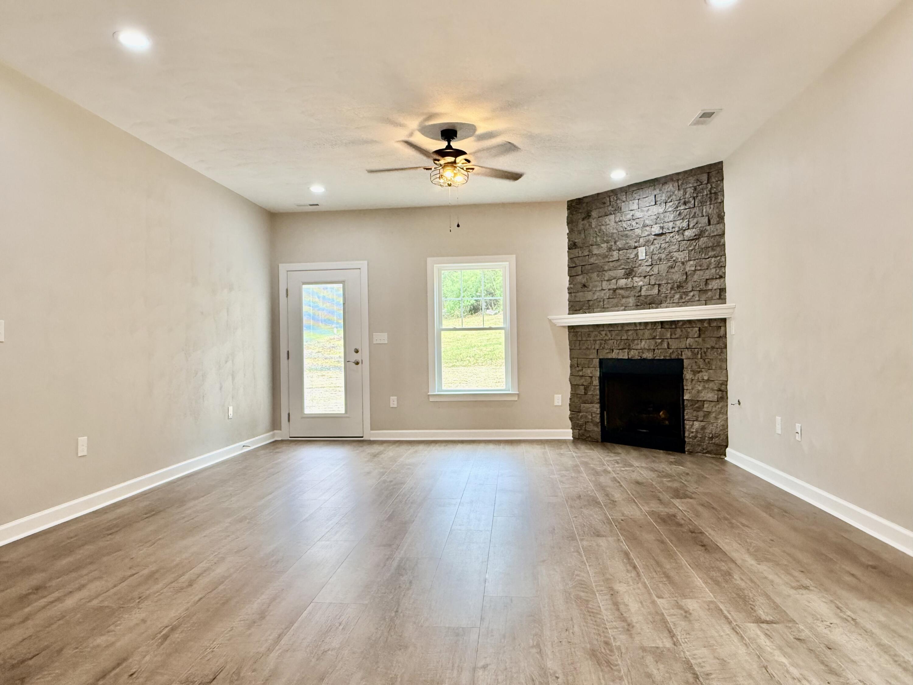 5185 Cove Road Roanoke, VA 24019 - Photo 9 of 18 an empty room with windows fireplace and a wooden floor