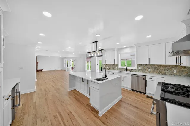 a kitchen with a sink stove and wooden floor
