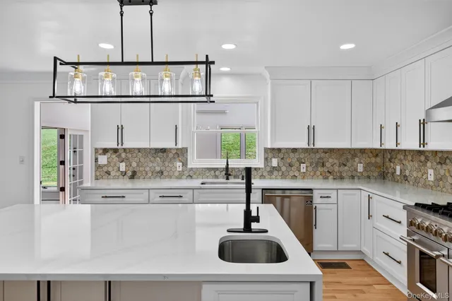 a kitchen with stainless steel appliances a sink a stove and cabinets