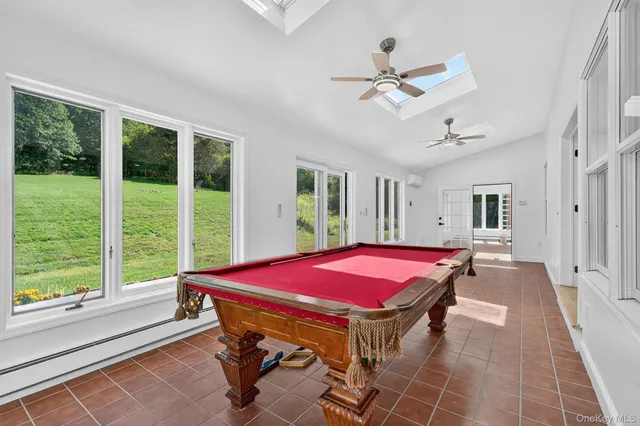 a dinning room with pool table and ceiling fan
