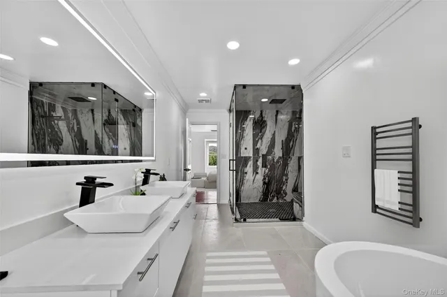 a bathroom with a tub sink and mirror
