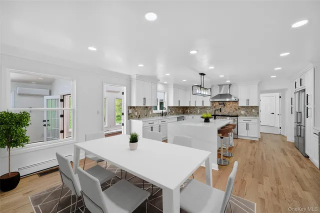 a kitchen with a dining table chairs wooden floor and appliances