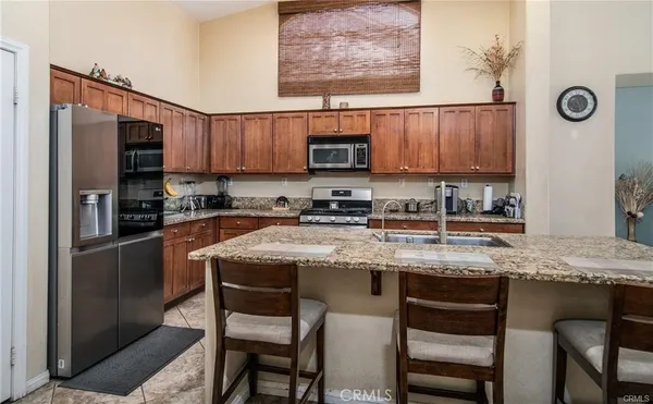 a kitchen with stainless steel appliances granite countertop a stove a sink dishwasher and cabinets with wooden floor