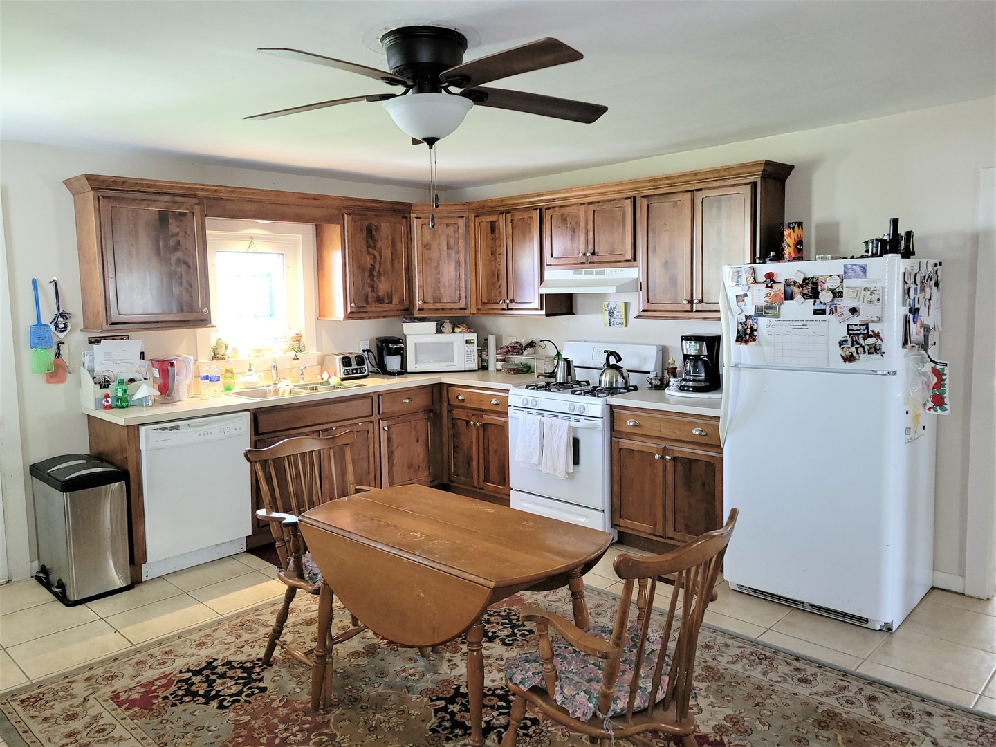11718 Thayer Road Hebron, IL 60034 - Photo 5 of 9 a kitchen with a dining table chairs refrigerator and cabinets