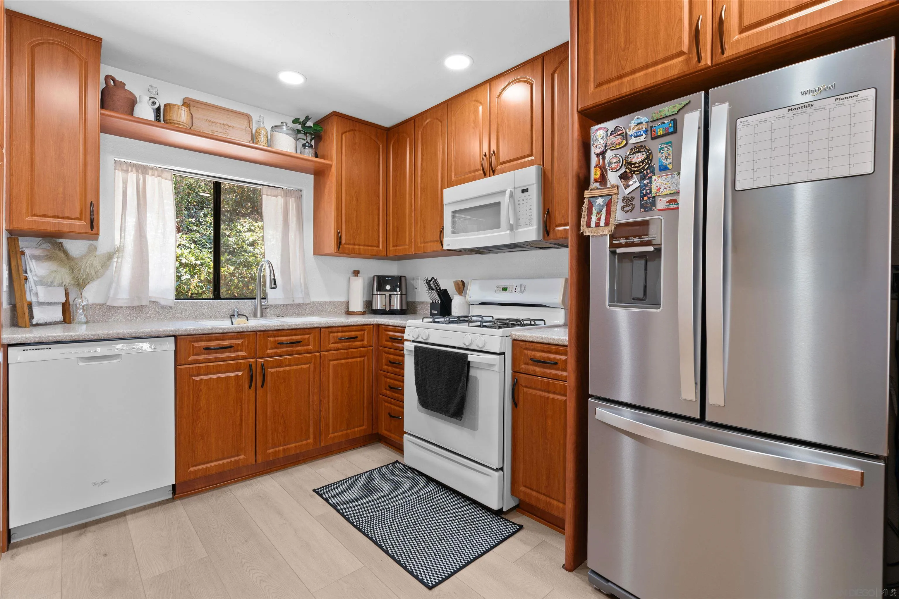 10781 Riderwood Terrace, Unit B Santee, CA 92071 - Photo 7 of 31 a kitchen with stainless steel appliances a refrigerator sink and cabinets