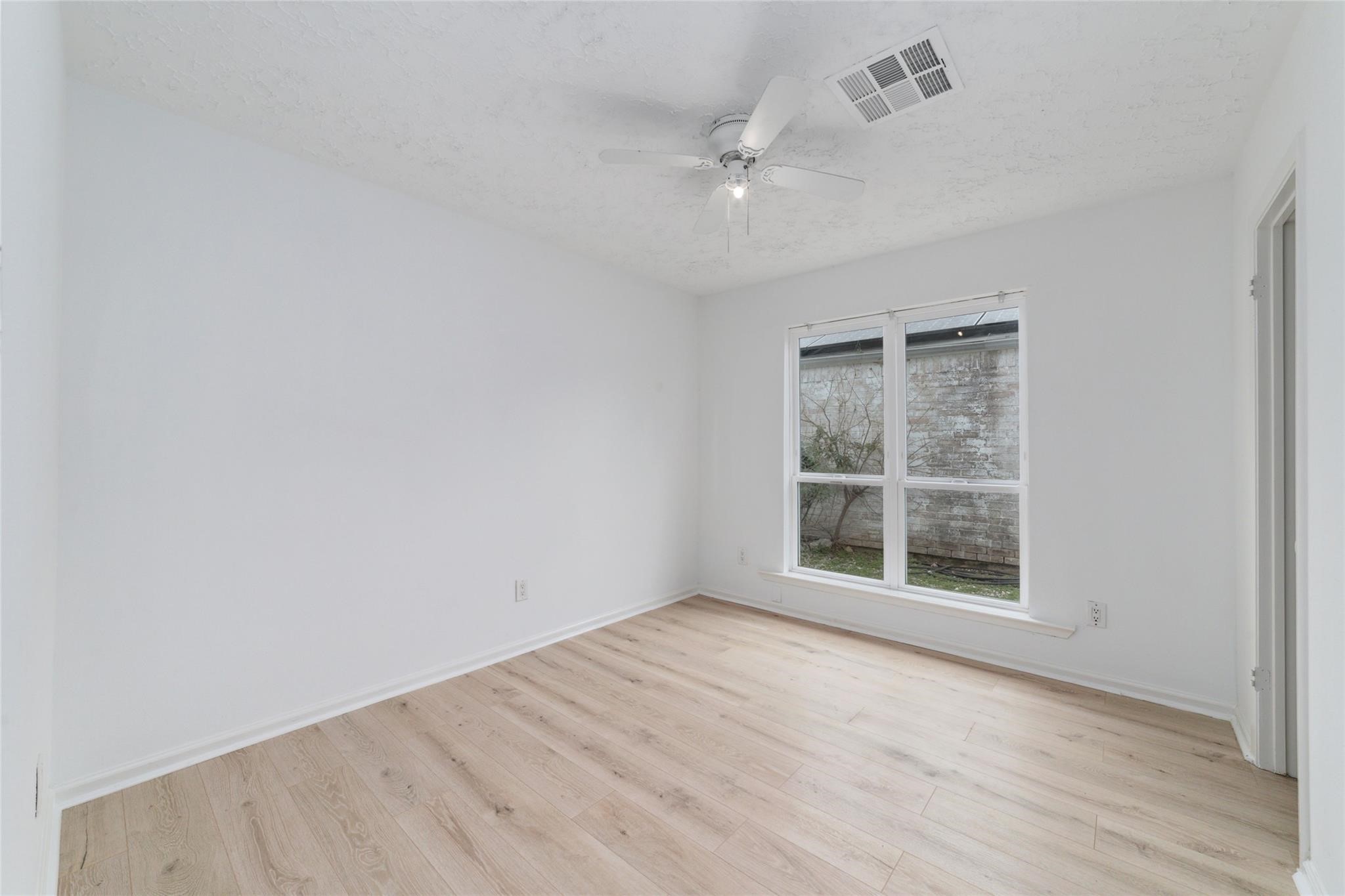 16123 Ridgegreen Drive Houston, TX 77082 - Photo 11 of 21 an empty room with wooden floor cabinet and windows