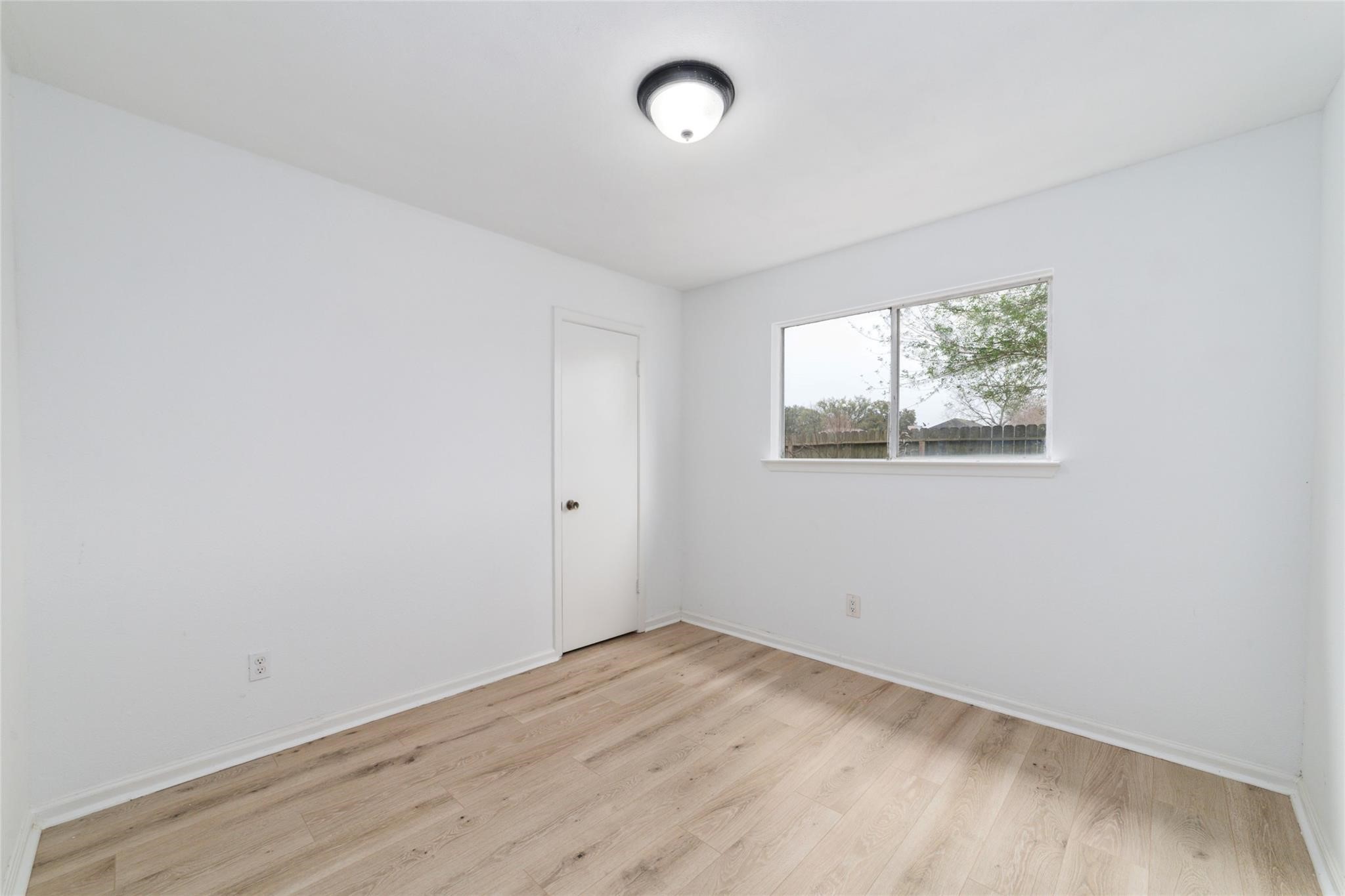 16123 Ridgegreen Drive Houston, TX 77082 - Photo 17 of 21 an empty room with wooden floor and windows