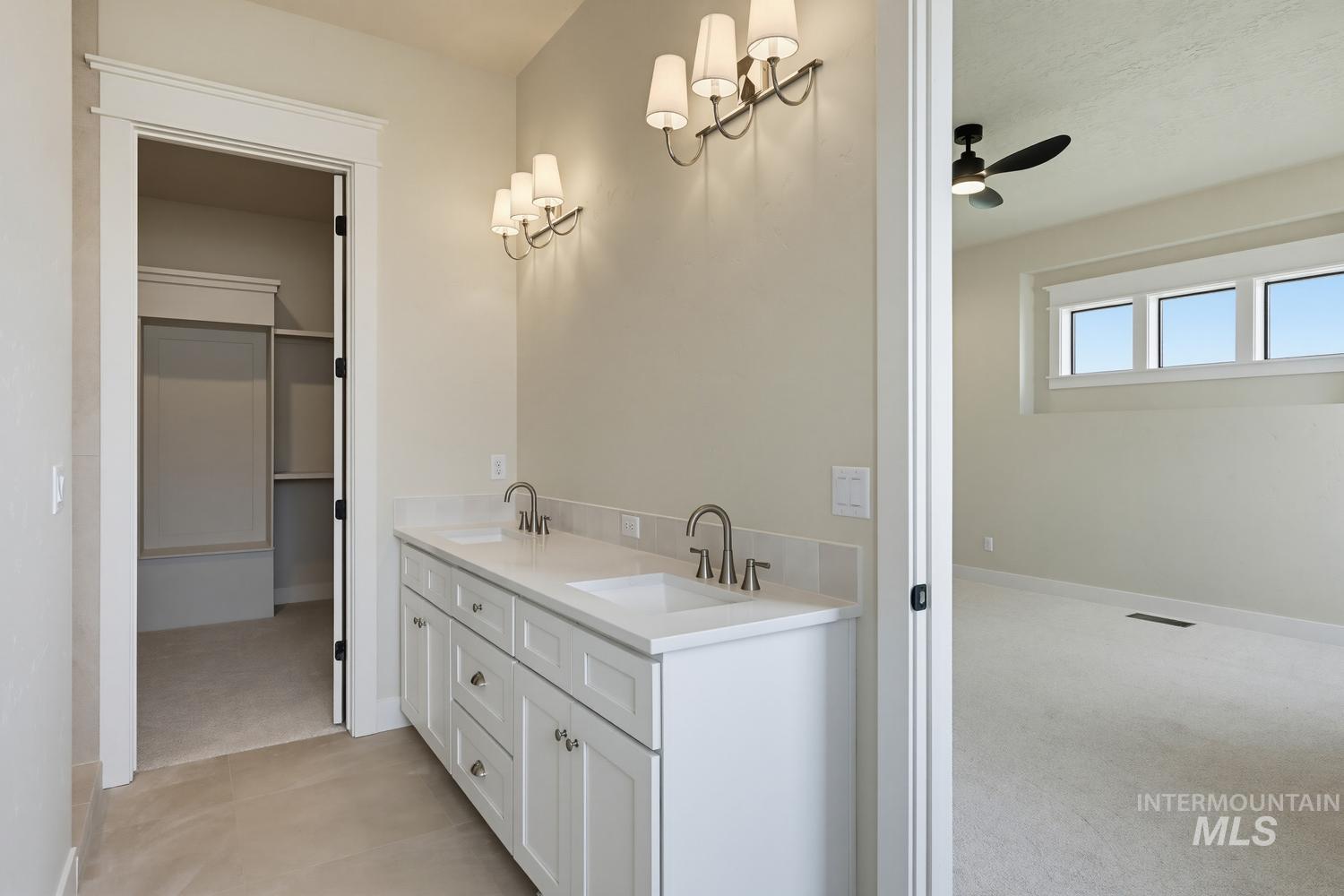 5054 Heritage Drive Marsing, ID 83639 - Photo 30 of 38 Double vanity with white cabinetry, dual undermount sinks, and wall-mounted sconces