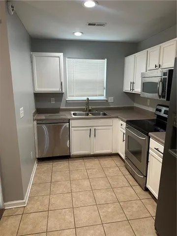 a kitchen with a sink a stove and cabinets