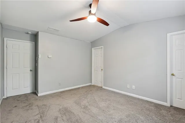 a view of an empty room and a chandelier fan