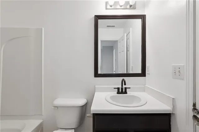 a bathroom with a toilet sink and mirror