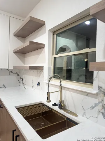 a kitchen with a sink and a stove top oven