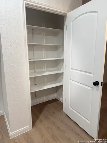 a view of walk in closet with empty racks