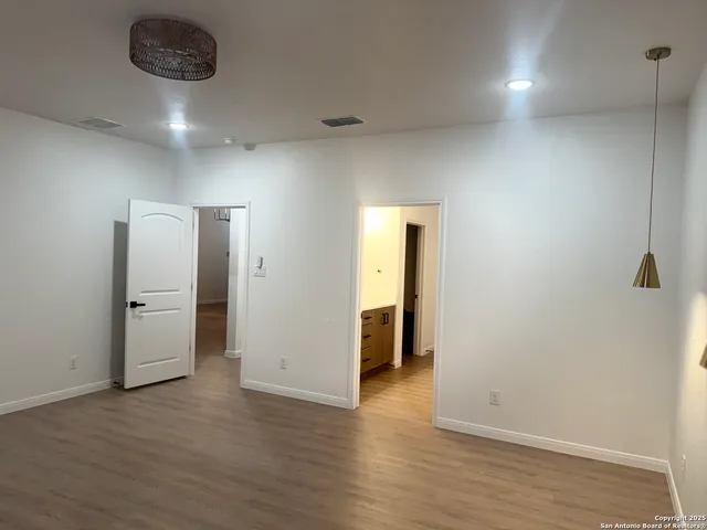 an empty room with wooden floor and entrance