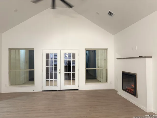 an empty room with wooden floor and fireplace