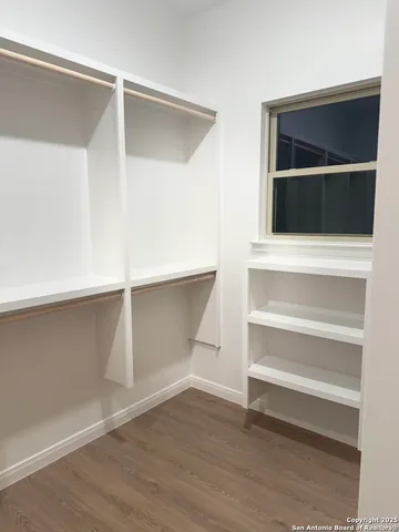 a living room with walk in closet and wooden floor