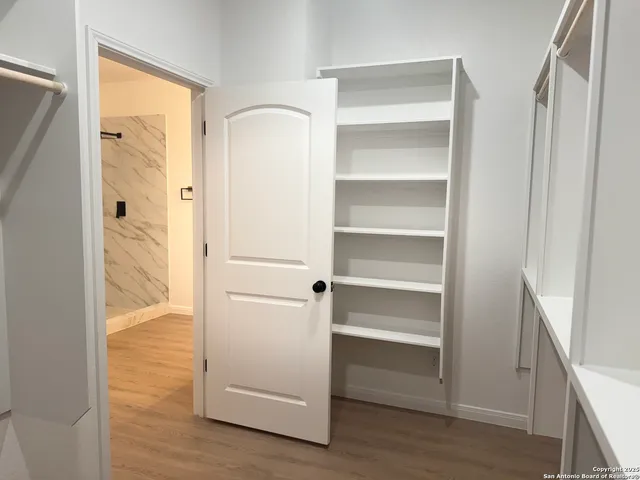 a view of walk in closet with empty racks