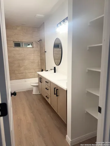 a bathroom with a double vanity sink mirror and toilet