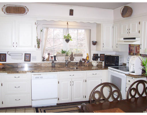 61 Shaw Road Brookline, MA 02467 - Photo 2 of 4 a kitchen with granite countertop white cabinets white stainless steel appliances and a window