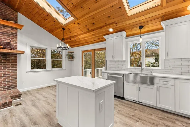 a large white kitchen with sink and cabinets