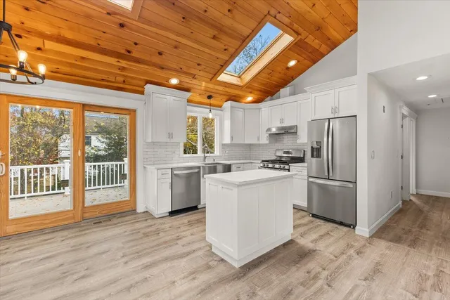 a kitchen with a refrigerator and a stove top oven