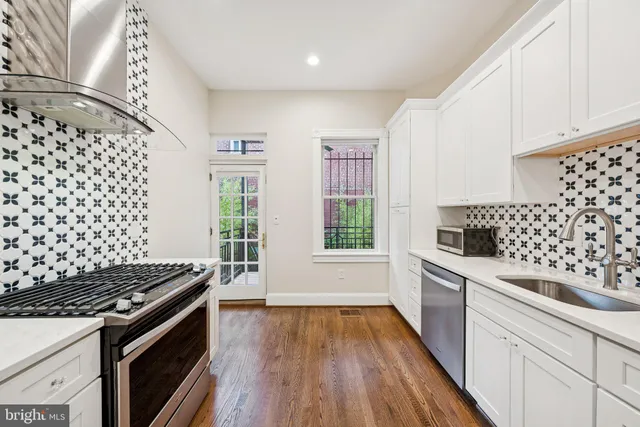 a kitchen with granite countertop a stove and wooden floor