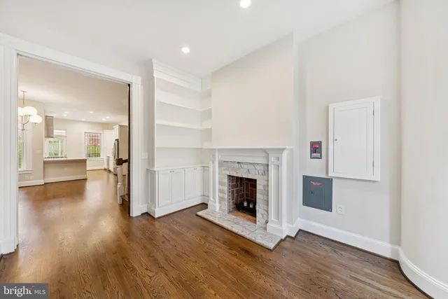 a view of a livingroom with wooden floor and a kitchen