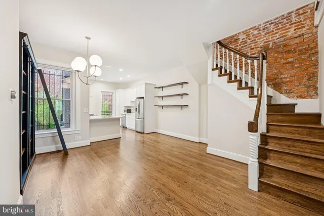 a view of a livingroom with wooden floor and stairs