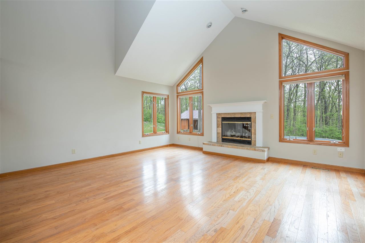 2976 West Forest Road Freeport, IL 61032 - Photo 4 of 35 an empty room with wooden floor fireplace and windows