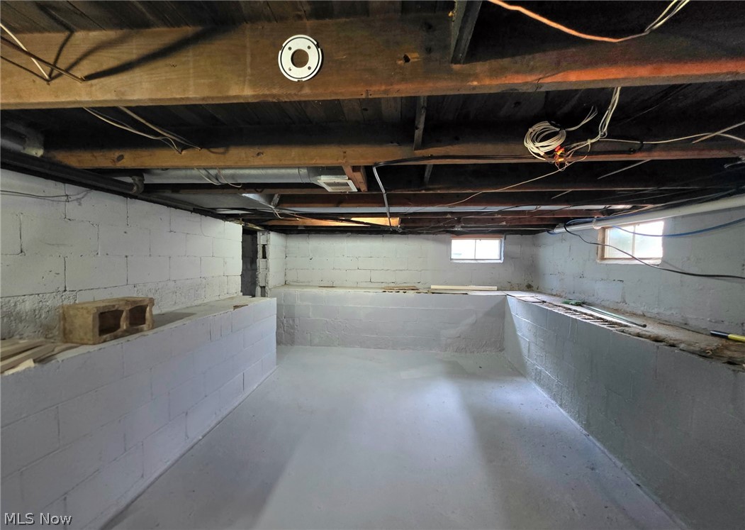 2335 West River Road Newton Falls, OH 44444 - Photo 27 of 36 Basement space featuring exposed wooden ceiling joists and painted block walls