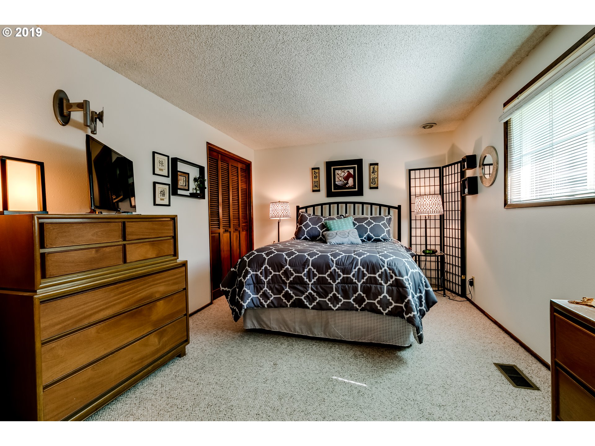 537 66th Street Springfield, OR 97478 - Photo 14 of 32 a bedroom with a bed a dresser and painting on the wall