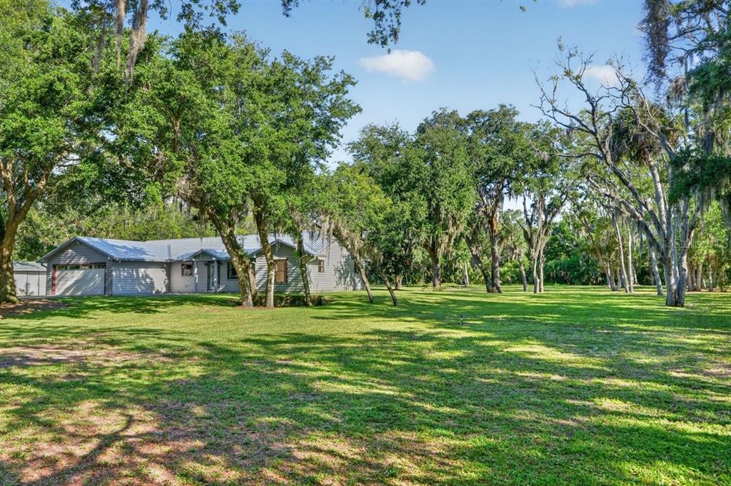 171 William Street Edgewater, FL 32141 - Photo 33 of 40 a backyard of a house with lots of green space and fountain