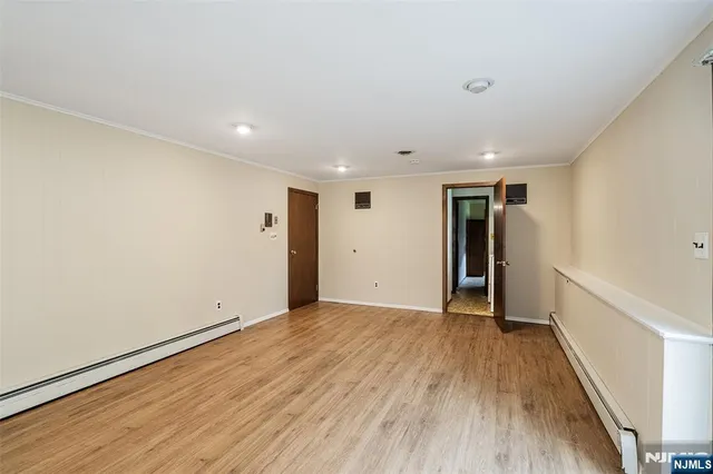 a view of an empty room with wooden floor