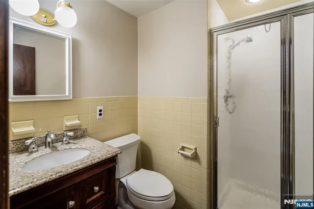 a bathroom with a granite countertop sink toilet and shower