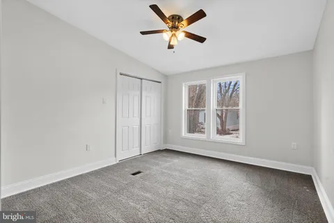 an empty room with a window and a fan