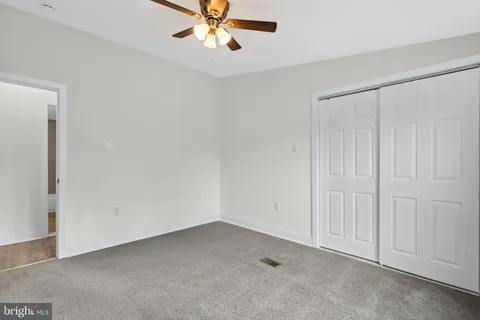 an empty room with a chandelier fan