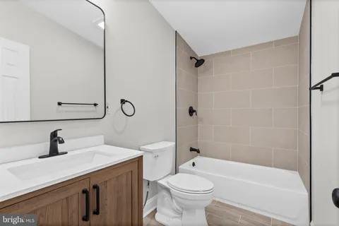 a bathroom with a sink a toilet a mirror a bathtub and shower