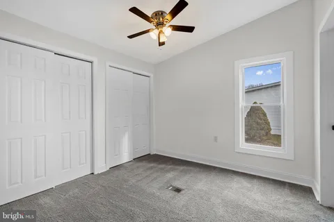 a view of an empty room with window and closet