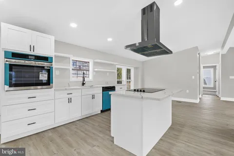a kitchen with stainless steel appliances kitchen island a stove and a wooden floors