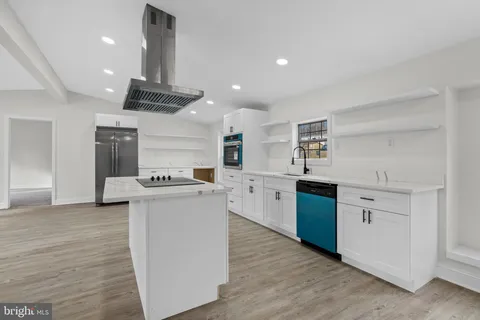 a kitchen with stainless steel appliances kitchen island a cabinets and wooden floor