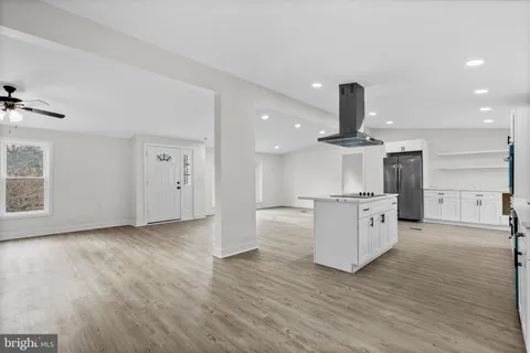 a view of kitchen with stainless steel appliances a refrigerator and wooden floor