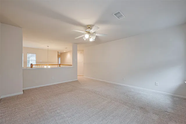 an empty room with a window and a fan