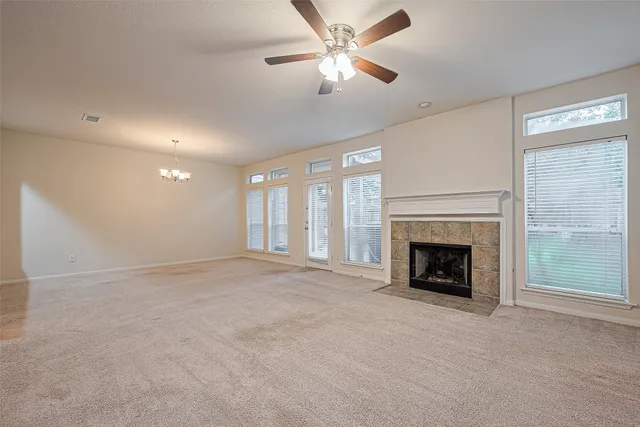 a view of an empty room with a fireplace and a window